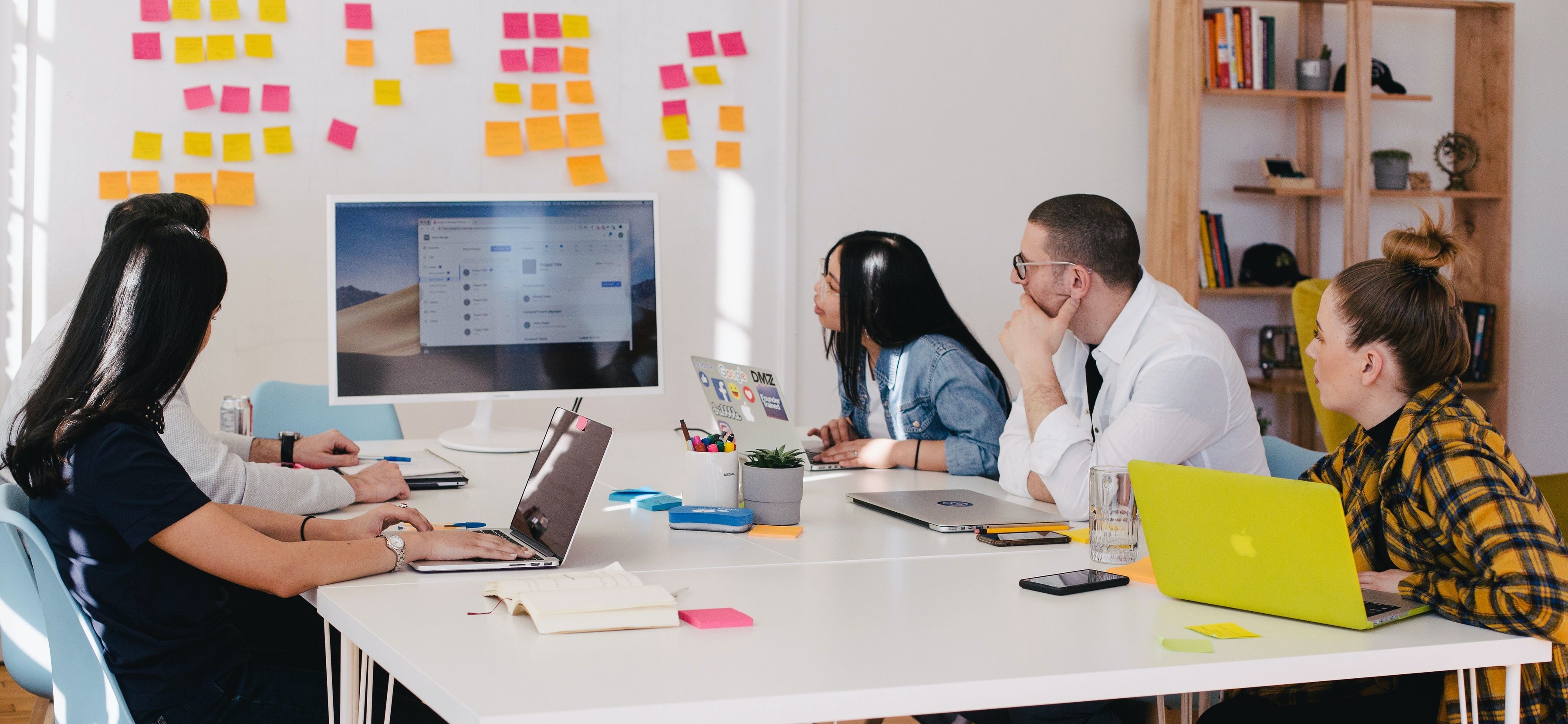 Group of co-workers sat around a table brain storming ideas.